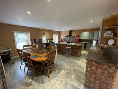 a large kitchen with a wooden table and chairs at Belton House Guest Rooms in Wanlockhead