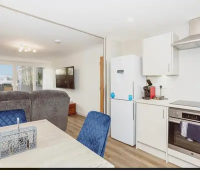 a kitchen and living room with a white refrigerator at Caul View Apartment in Dumfries in Dumfries