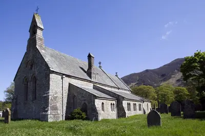 an old church in a field with a hill in the background at Sandhills Farm in Bassenthwaite