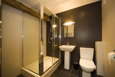 a bathroom with a shower and a toilet and a sink at Sandhills Farm in Bassenthwaite