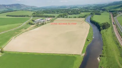 an aerial view of a field next to a river at Clyde Cottage in Lamington