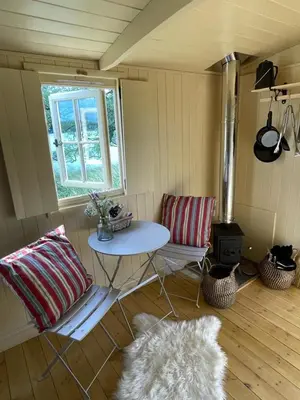 a room with a table and a window and a rug at The Secret Shepherds Hut- Off Grid Retreat in New Galloway