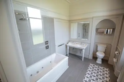 a bathroom with a tub and a toilet and a sink at Cornhill Castle in Biggar
