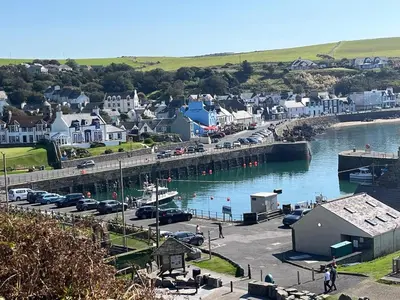 a view of a harbor with cars parked next to the water at Cosy Holiday Home Portpatrick in Portpatrick