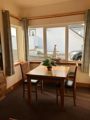 a dining room with a table and chairs and a window at Cosy Holiday Home Portpatrick in Portpatrick