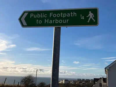 a green street sign for public footpath to harbour at Cosy Holiday Home Portpatrick in Portpatrick