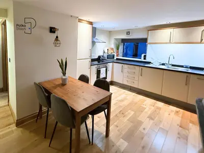 a kitchen with a wooden table and chairs in a room at The Stables Lake District Retreat by PolkaStays in Troutbeck
