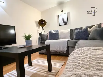 a living room with a couch and a table at The Stables Lake District Retreat by PolkaStays in Troutbeck