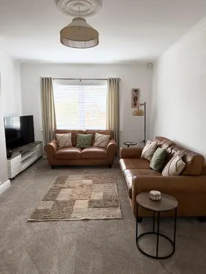 a living room with two couches and a television at Modern 2 bed with secure driveway in Dumfries