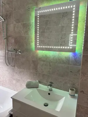 a bathroom with a tub and a sink and a mirror at Modern 2 bed with secure driveway in Dumfries