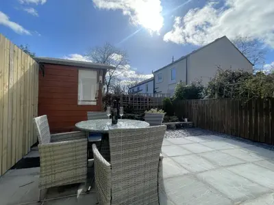a patio with a table and chairs and a fence at Farmers Retreat in Keswick