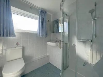 a bathroom with a toilet and a sink and a shower at Farmers Retreat in Keswick