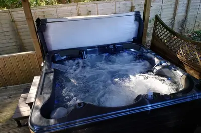 a jacuzzi tub filled with water on a deck at Wildwood Cabin - Sleeps 6 Hot Tub & Parking in Beattock