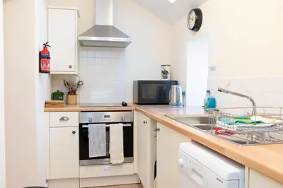 a kitchen with a sink and a stove top oven at Cross Cottage in Gatehouse of Fleet