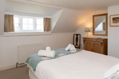 a bedroom with a bed with towels on it at Cross Cottage in Gatehouse of Fleet