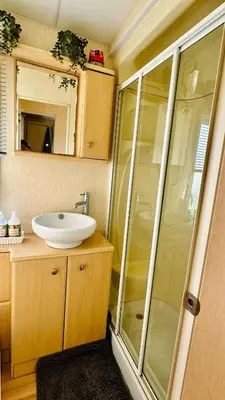 a bathroom with a sink and a glass shower at Shoreline Stay in Port Carlisle