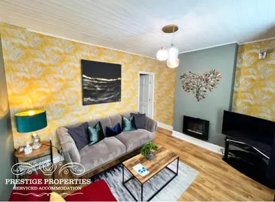a living room with a couch and a fireplace at Harcourt by Prestige Properties SA in Workington