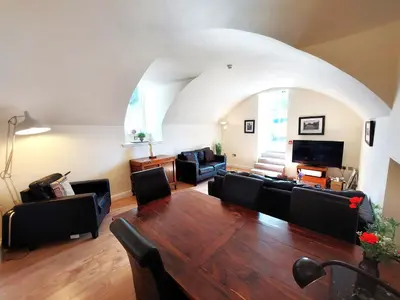 a living room with a large wooden table and chairs at Ensuite rooms, self-catering in shared kitchens in Dumfries