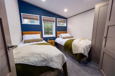 two beds in a room with blue walls at Crofthead Holiday Park in Ayr