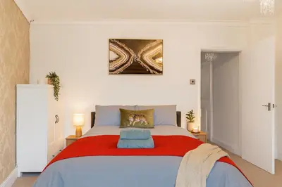 a bedroom with a large bed with a red blanket at Workington Haven - 3 Bed Home in Workington