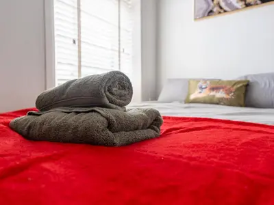 a towel sitting on top of a red bed at Workington Haven - 3 Bed Home in Workington
