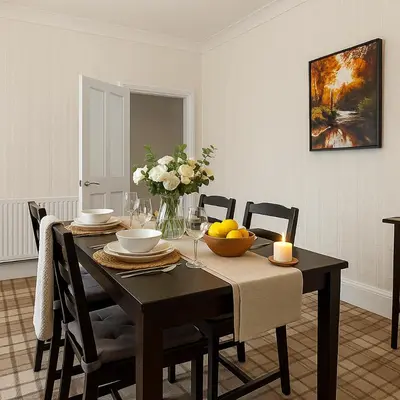 a dining room table with a candle and flowers on it at Workington Haven - 3 Bed Home in Workington