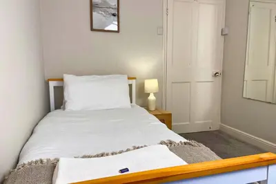 a bedroom with a white bed with a wooden frame at Secluded Hot Tub, Pool, Escape in Bootle