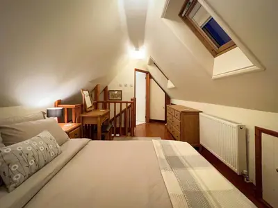 a bedroom with a bed and a couch and a window at The Gower Cottages in Moffat