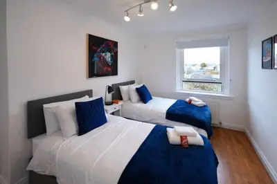 a bedroom with two beds and a window at Barassie Villa located near Troon in Troon