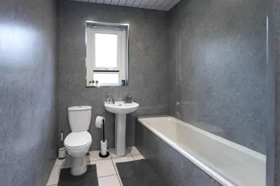 a bathroom with a toilet and a sink and a bath tub at Barassie Villa located near Troon in Troon