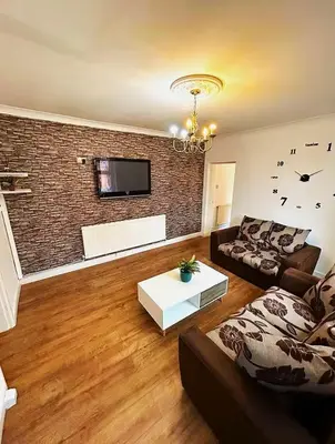 a living room with a couch and a brick wall at 5BR House w Garden Near Stadium in Moffat
