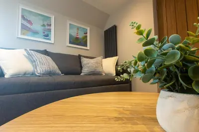 a living room with a couch and a table at Stoneyloft Modern Apartment in Glen Vine in Glen Vine