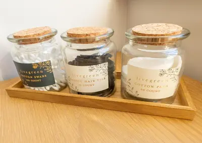 three glass jars sitting on a wooden tray at Stoneyloft Modern Apartment in Glen Vine in Glen Vine