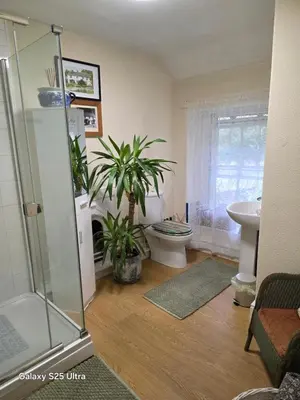 a bathroom with a shower and a toilet and a sink at Blea Tarn Farmhouse B&B in Ambleside