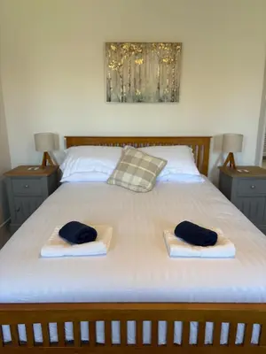 two towels on a bed with two pillows on it at Modern 3-Bedroom, central Kirkcudbright in Kirkcudbright