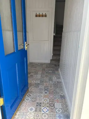 a hallway with a blue door and a tile floor at Modern 3-Bedroom, central Kirkcudbright in Kirkcudbright