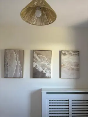 four pictures hanging on a wall with a fan at Modern 3-Bedroom, central Kirkcudbright in Kirkcudbright