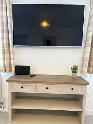 a large television on top of a dresser in a room at Modern 3-Bedroom, central Kirkcudbright in Kirkcudbright