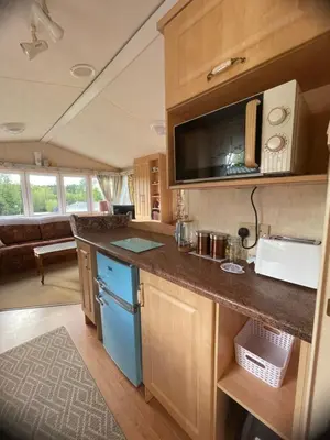a kitchen with a counter and a sink in a caravan at Grannys Vintage Coastal Caravan in Kippford