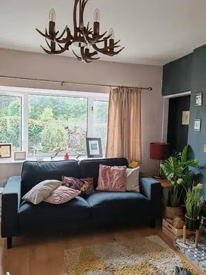 a blue couch in a living room with a window at Cosy cottage near Thornhill in Closeburn