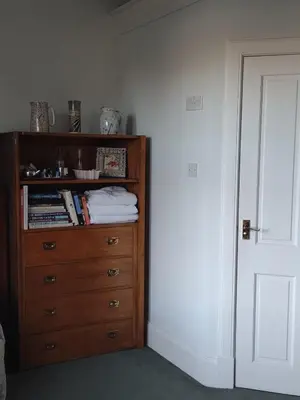 a wooden dresser in a room with a white wall at 95 St Mary Street in Kirkcudbright