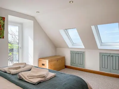 a bedroom with skylights and a bed in a attic at The Cheese Loft in Drummore