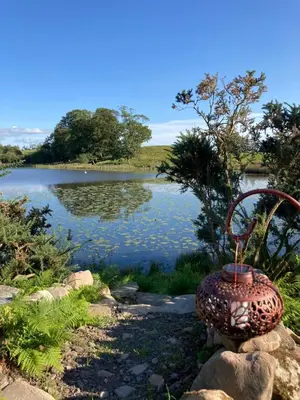 a vase sitting next to a body of water at Barmoffity Shepherds Hut in Kirkpatrick Durham