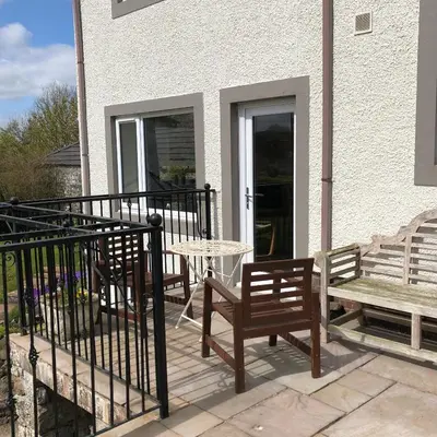 a patio with two chairs and a table and a bench at Pottery Cottage - close to the Lake District in Skelton