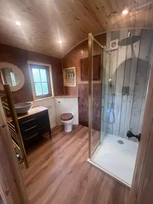 a large bathroom with a shower and a toilet at Mountain View Shepherds Hut in Penrith