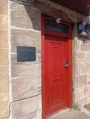 a red door on the side of a brick building at Hotel Room in Maybole for Work Travel & Leisure in Maybole