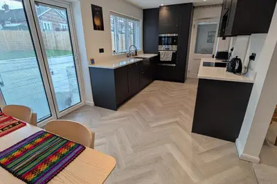 a kitchen with black cabinets and a wooden floor at 3 Bed-Sleeps 5-Garden-Parking-Pets in Carlisle
