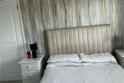 a bedroom with a white bed with a wooden wall at 3 Bed-Sleeps 5-Garden-Parking-Pets in Carlisle