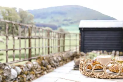 a table with a cake and a plate of food at North Lakes - The Byre Holiday Cottage in Penrith