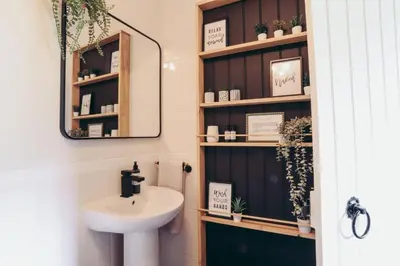 a bathroom with a sink and a mirror at North Lakes - The Fold Holiday Cottage in Penrith